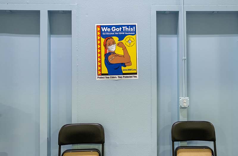 A sign promoting vaccination among Native American tribal members hangs on the wall at a COVID-19 vaccination clinic at the Denver Indian Center on Friday, March 12, 2021.