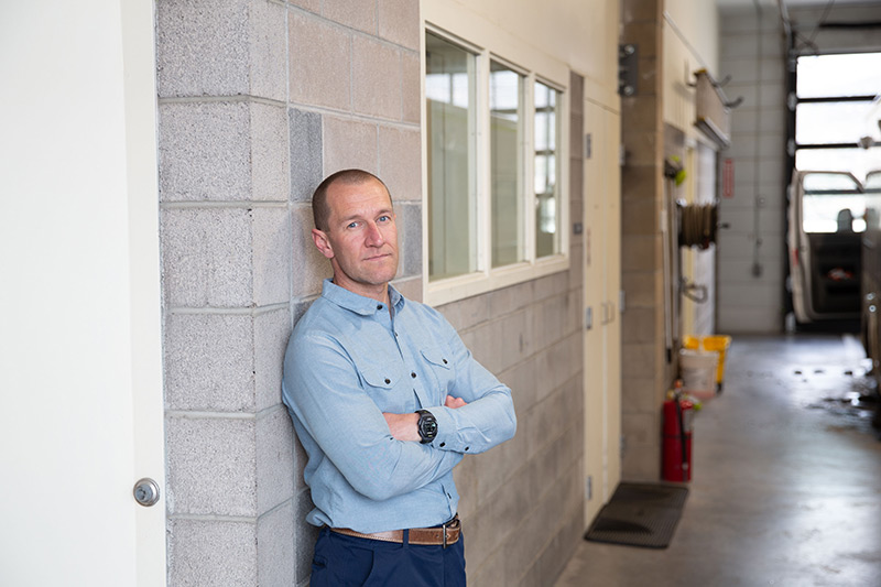 Ryan Bush of Eagle County Paramedic Services stands with arms crossed outside the Edwards paramedic station in Edwards, Colorado.